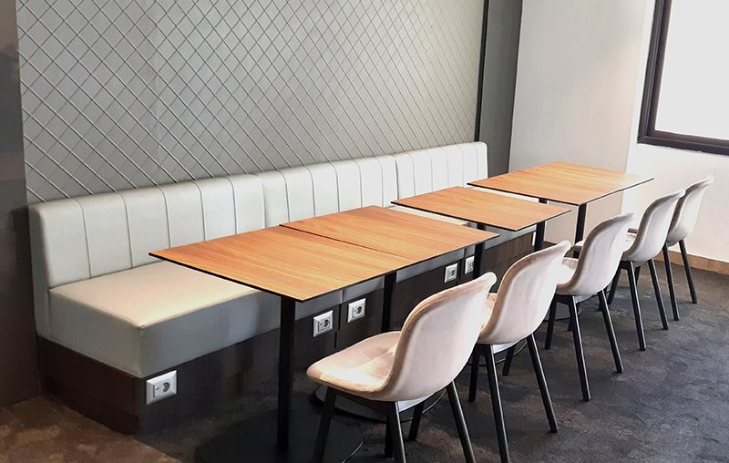 L'espace cafétéria et ses tables de travail